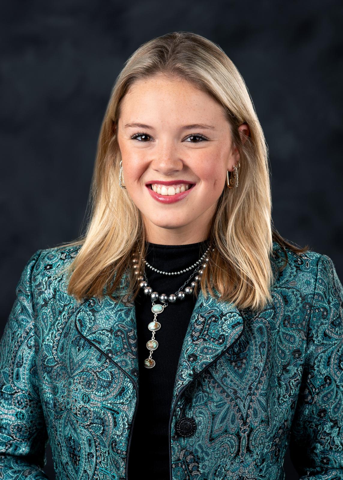 girl in green blazer on black background