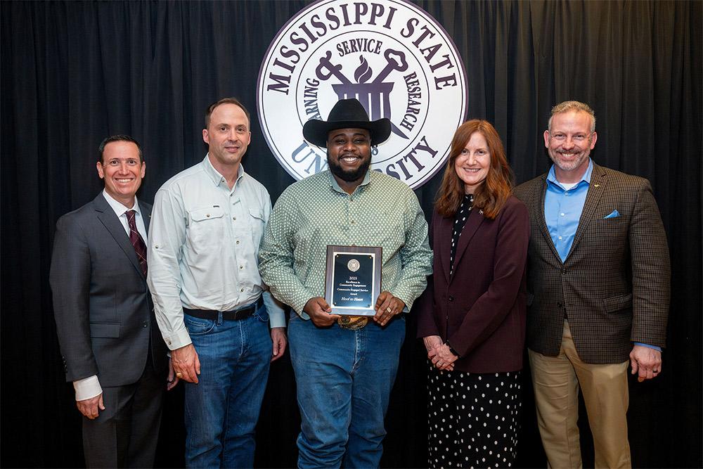 Accepting an MSU Community Engagement Award for the “Hoof to Heart” program are Professor Clay Cavinder, second from left, on behalf of Extension Associate III Lori Irvin, and Agricultural Technician Narsis Whigham, center, Department of Animal and Dairy Sciences, from Interim Executive Director for Outreach and Engagement Joe Fratesi, left, and Associate Vice President for the Division of Agriculture, Forestry and Veterinary Medicine Ashli Brown and Senior Vice Provost Brent Fountain, right.