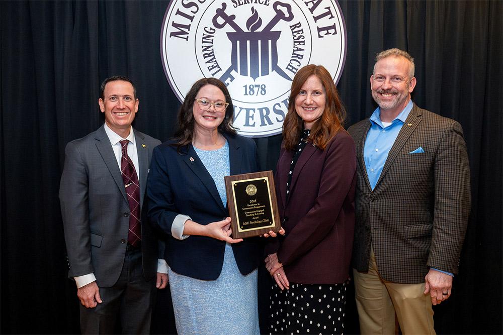 Associate Clinical Professor Emily Stafford, second from left, accepts a Community Engagement Award for MSU’s Psychology Clinic from Interim Executive Director for Outreach and Engagement Joe Fratesi, left, Associate Vice President for the Division of Agriculture, Forestry and Veterinary Medicine Ashli Brown and Senior Vice Provost Brent Fountain.