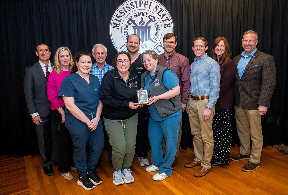 The “Preparing Practice-Ready Veterinarians” team accepts a Community Engagement Award from MSU leaders.