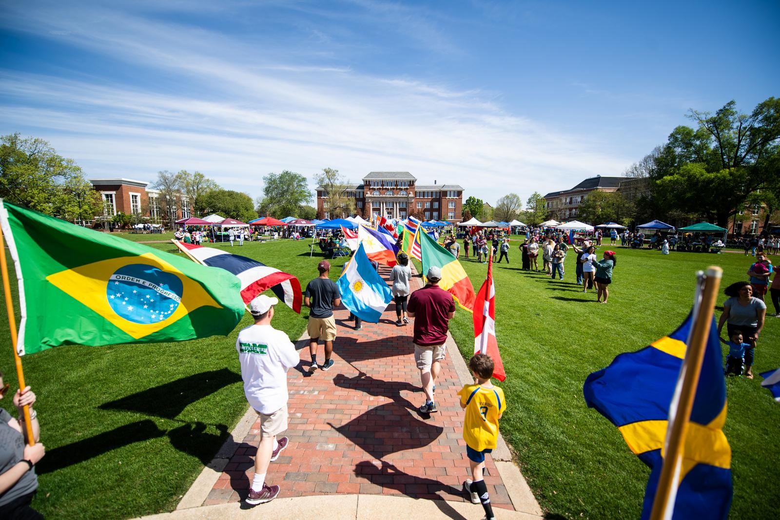 Participants carry international flags during MSU's annual International Fiesta