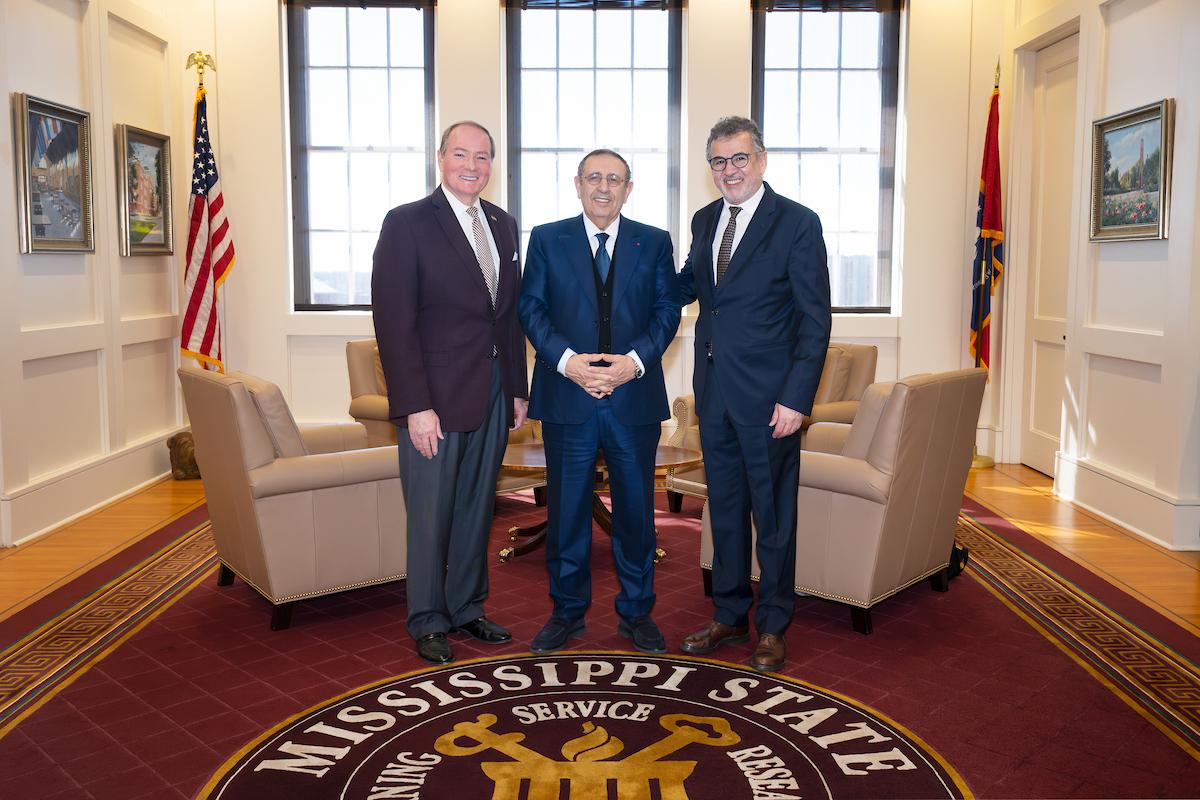 three men stand in MSU president's office
