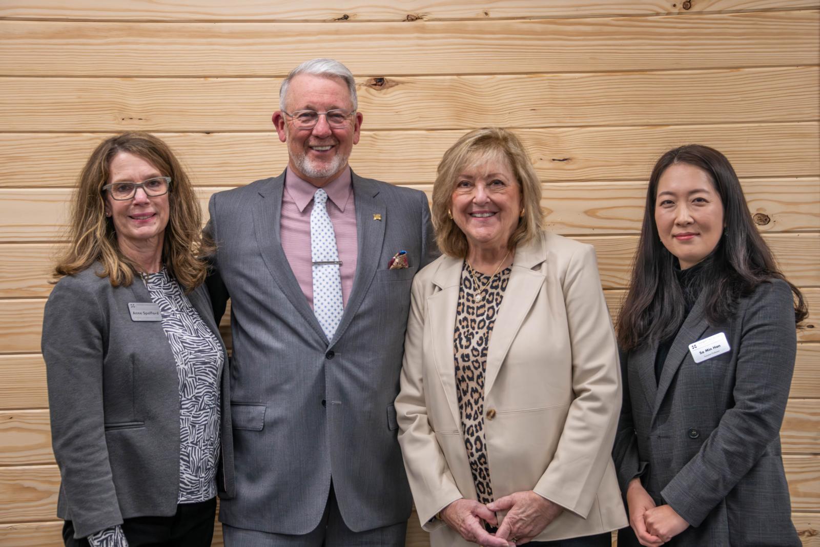 photo of four people celebrating a new endowed professor on the far right