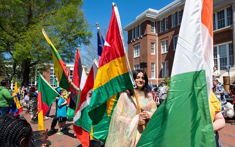 MSU International Fiesta participants parade various countries' flags across the Drill Field.