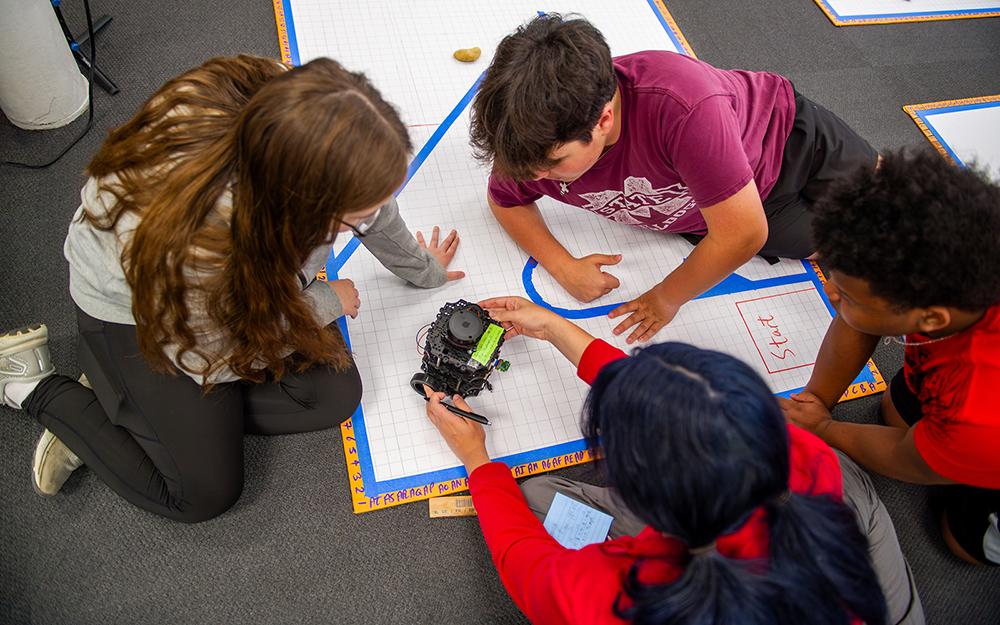Area students work with a robot during a Mississippi State-led artificial intelligence camp last summer.