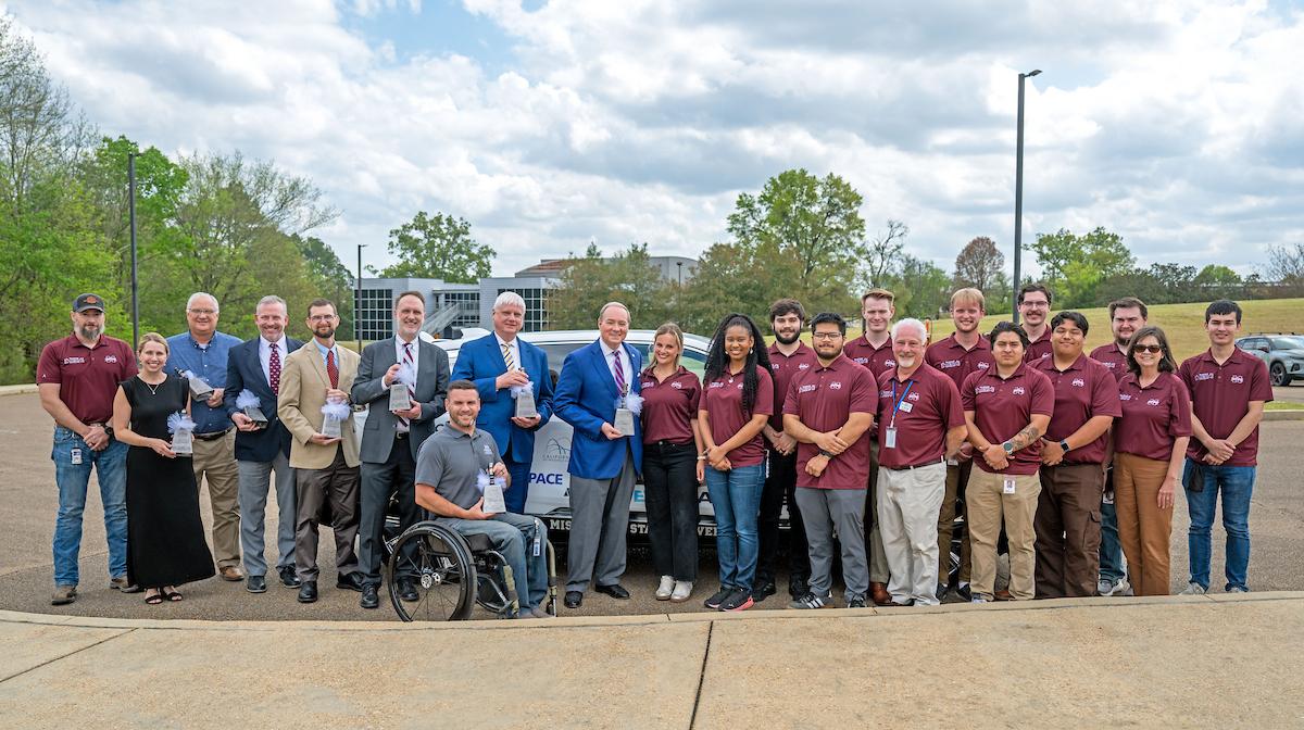 MSU admin pose in front of EcoCAR with team