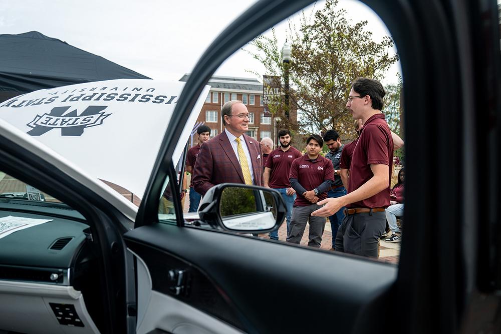 Mississippi State President Mark E. Keenum, left, speaks with MSU EcoCAR team members during the organization’s fall vehicle showcase.