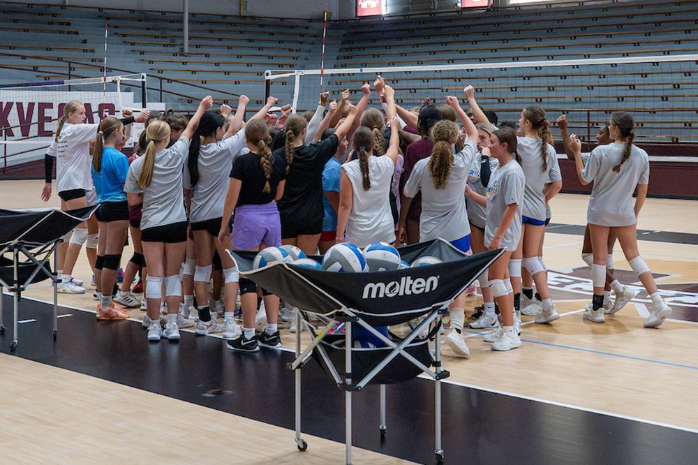 Mississippi State All Skills Volleyball Camp participants huddle together after practice.
