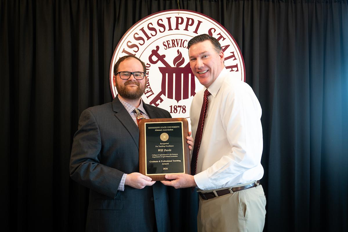 Jeff Davis, left, executive director of the MSU Alumni Association, presents the Alumni Association Outstanding Graduate Student Mentor Award to Ryan Folk.