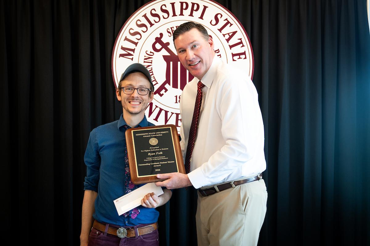 Jeff Davis, left, executive director of the MSU Alumni Association, presents the Alumni Association Outstanding Graduate Student Mentor Award to Ryan Folk. (Photo by Grace Cockrell)