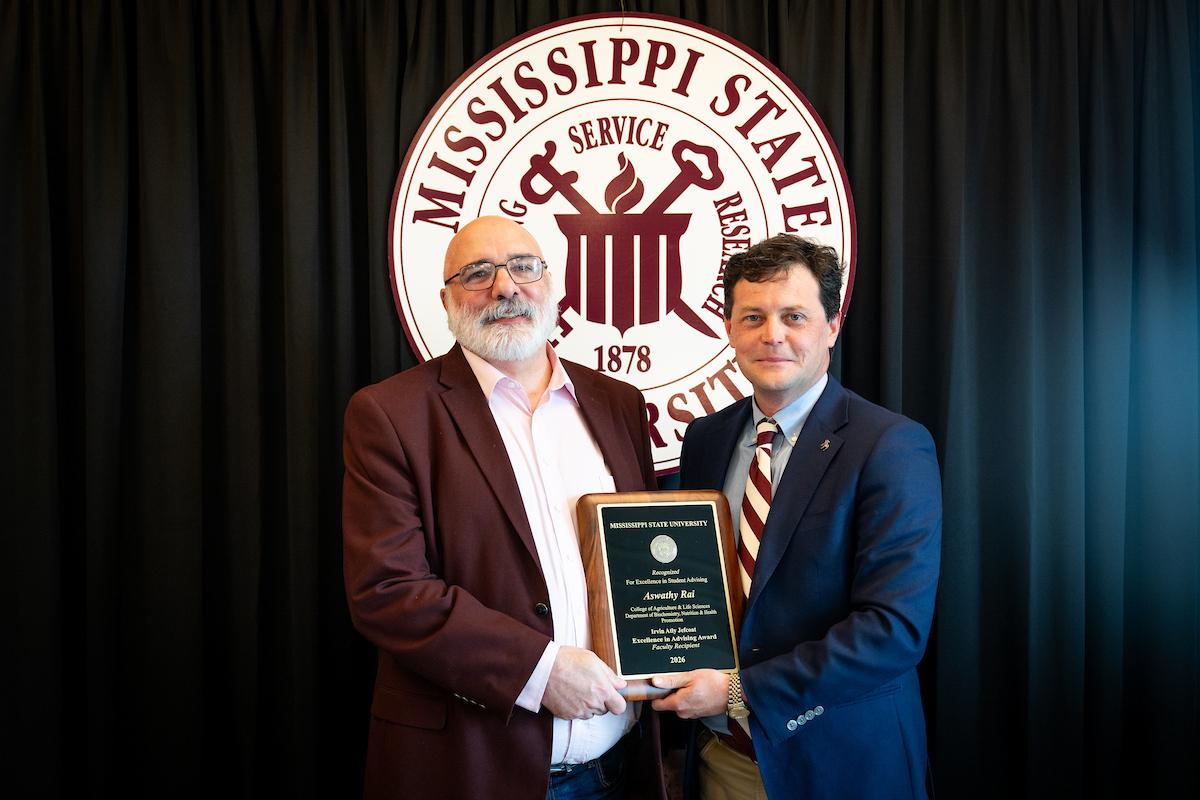 MSU Interim Associate Vice President for Strategic Partnerships Tabor Mullen, left, presents the Irvin Atly Jefcoat Excellence in Advising Award to Department of Biochemistry, Nutrition and Health Promotion Department Head Daniel Peterson, who received the award on behalf of faculty recipient Aswathy Rai.