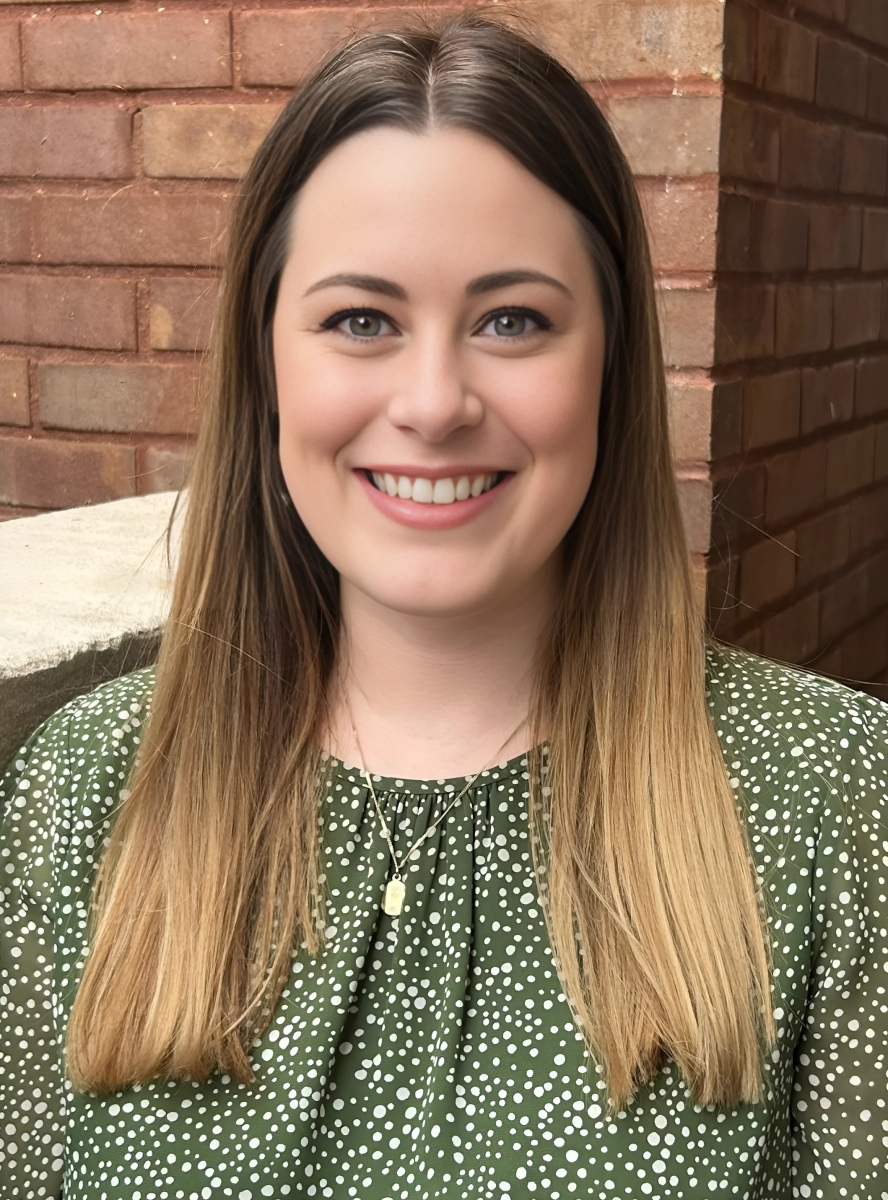 headshot of Christie Collins on a brick wall