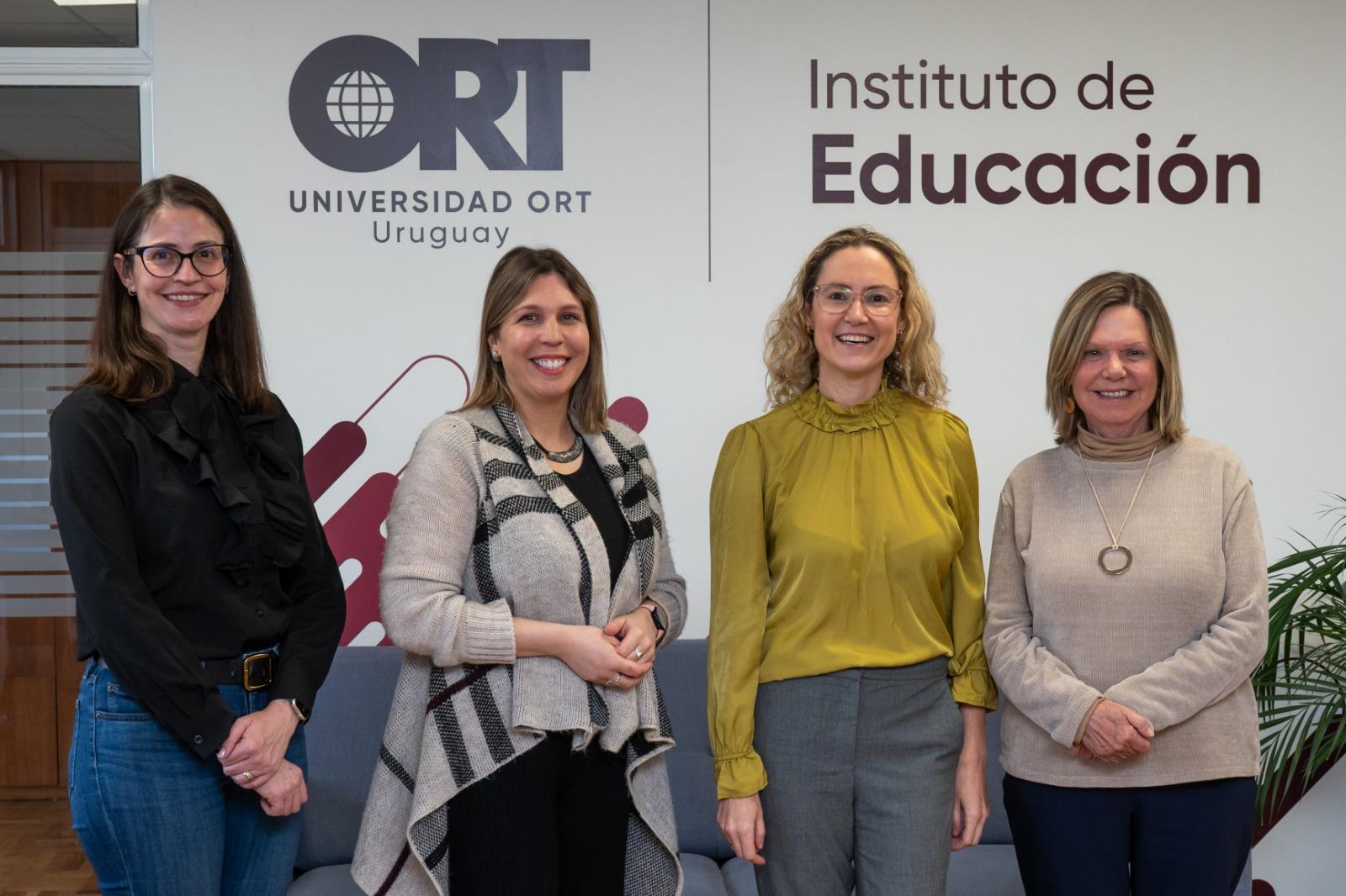 Four women stand in front of Universidad ORT Uruguay signage
