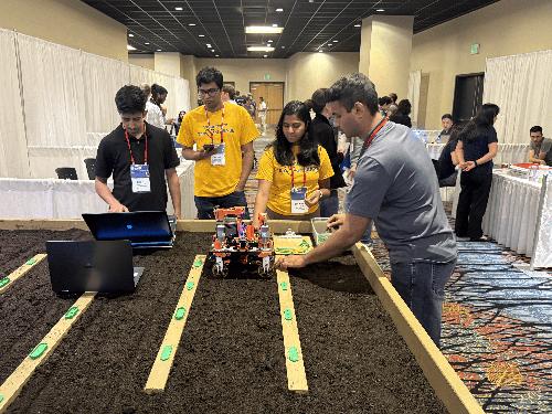 American Society of Agricultural and Biological Engineers judges evaluate the work of Mississippi State graduate students Bishal Adhikari of Nepal, left, and Moeen Ul Islam of Bangladesh, right.