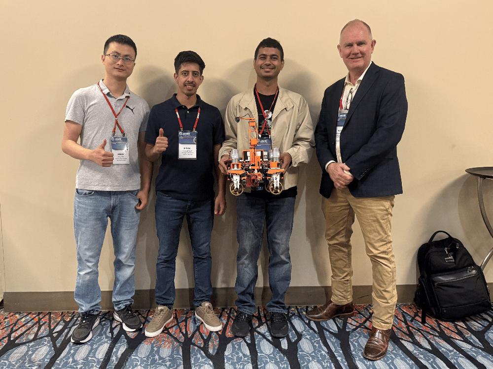 From left, Dong Chen, Mississippi State agricultural and biological engineering assistant professor, graduate students Bishal Adhikari of Nepal and Moeen Ul Islam of Bangladesh, and Alex Thomasson, professor and director of MSU’s Agricultural Autonomy Institute, pose with their robot during the American Society of Agricultural and Biological Engineers’ annual Robotics Student Design Competition in July.