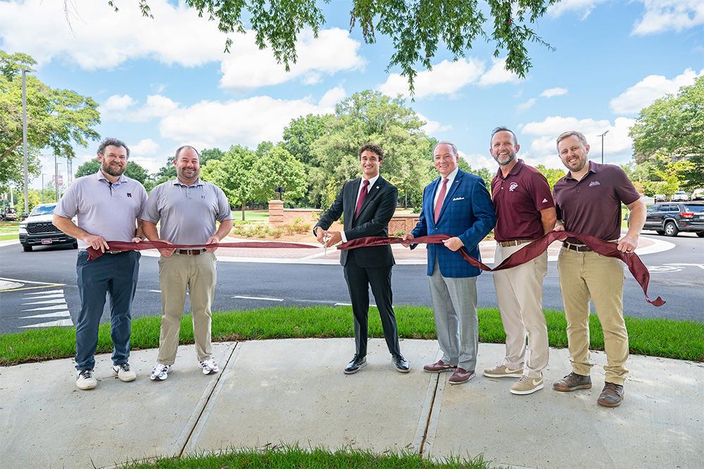 Cutting a maroon ribbon at the new traffic circle are MSU Director for Planning, Design and Construction Administration Ches Fedric; Associate Vice President for Administration Jeremiah Dumas; Student Association President Keegan Figueroa; MSU President Mark E. Keenum; Associate Vice President for Administration Saunders Ramsey; and Associate Director for Engineering Services Ben Stroud.