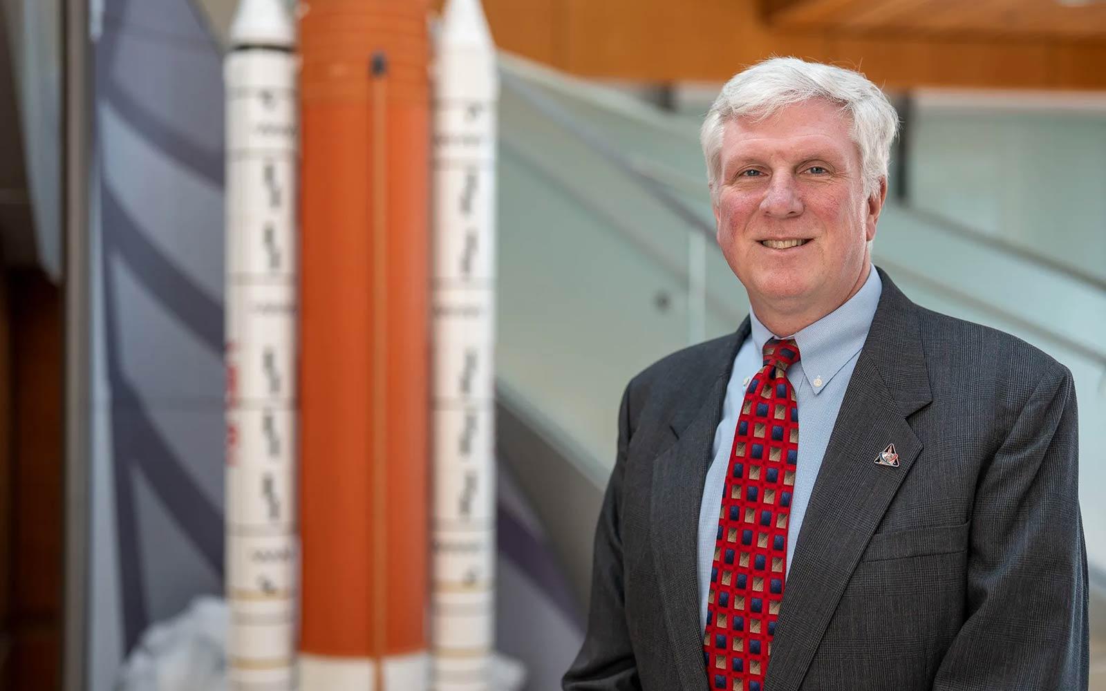 Photo of Matthew Ramsey in front of a model space shuttle.